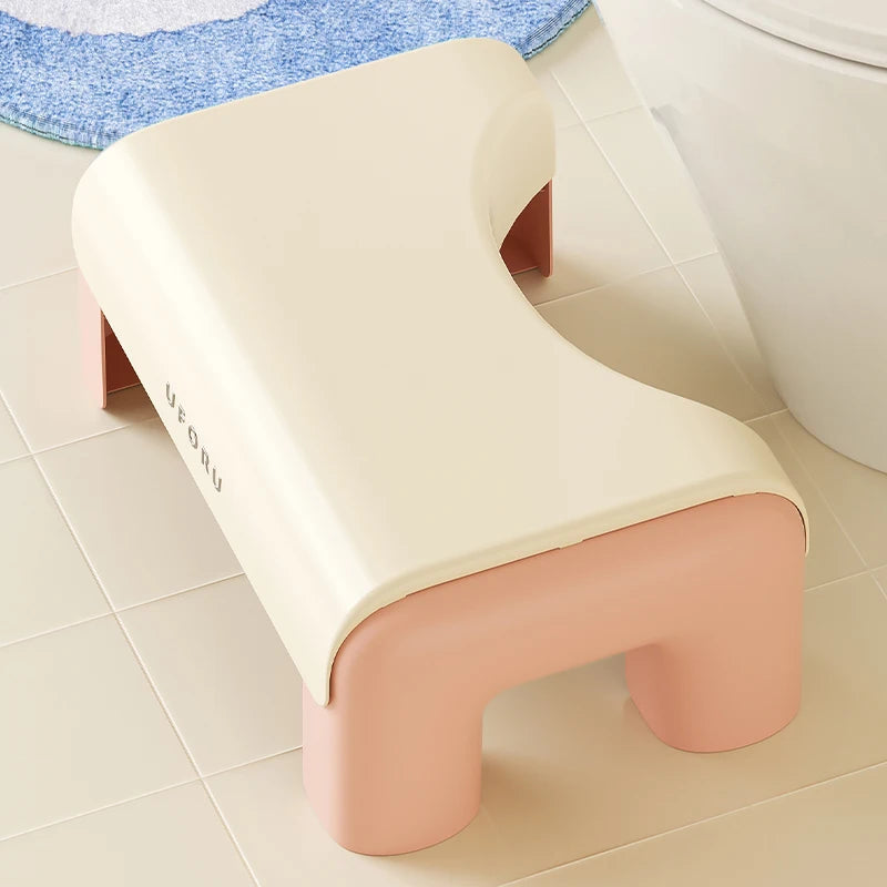 Beige and pink step toilet stool on a tiled bathroom floor