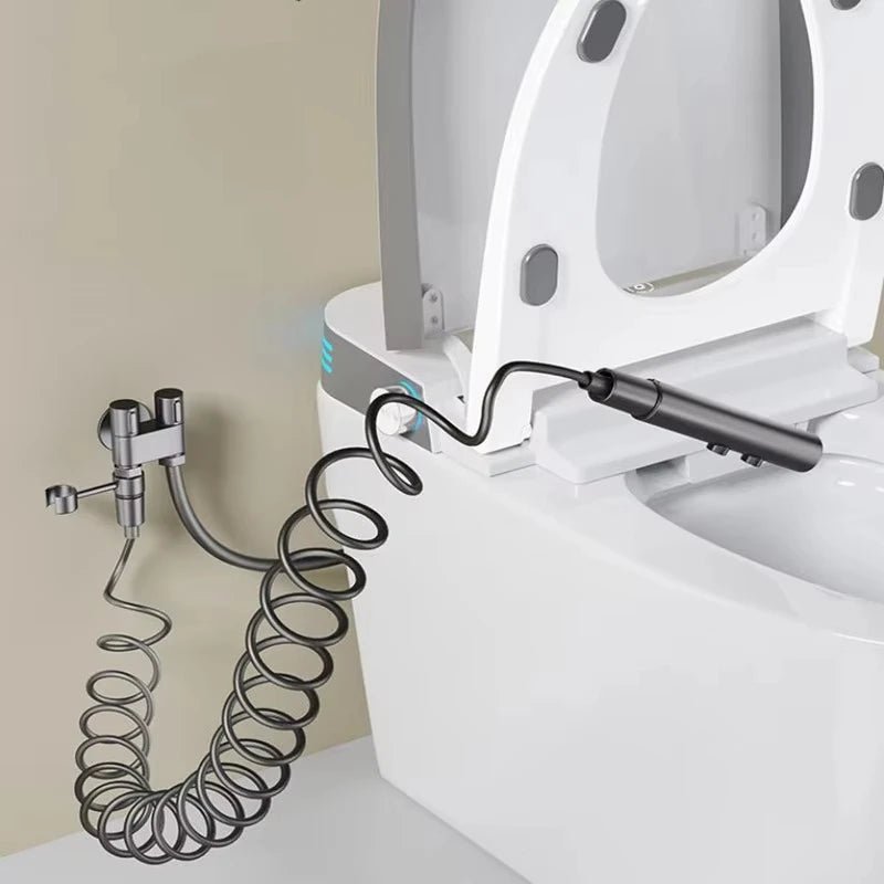 Bidet toilet gun with coiled hose attached to a toilet