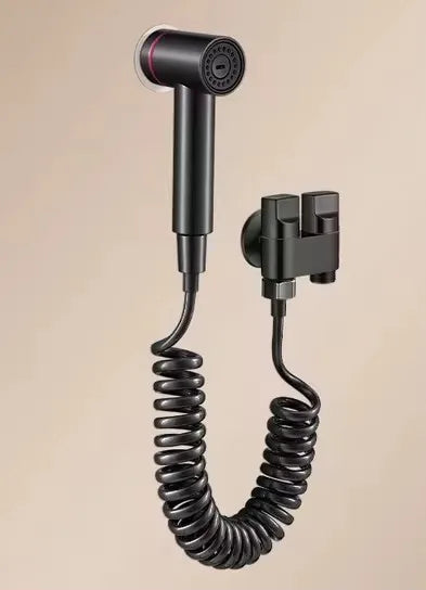 Black handheld shower head with coiled hose on a beige background