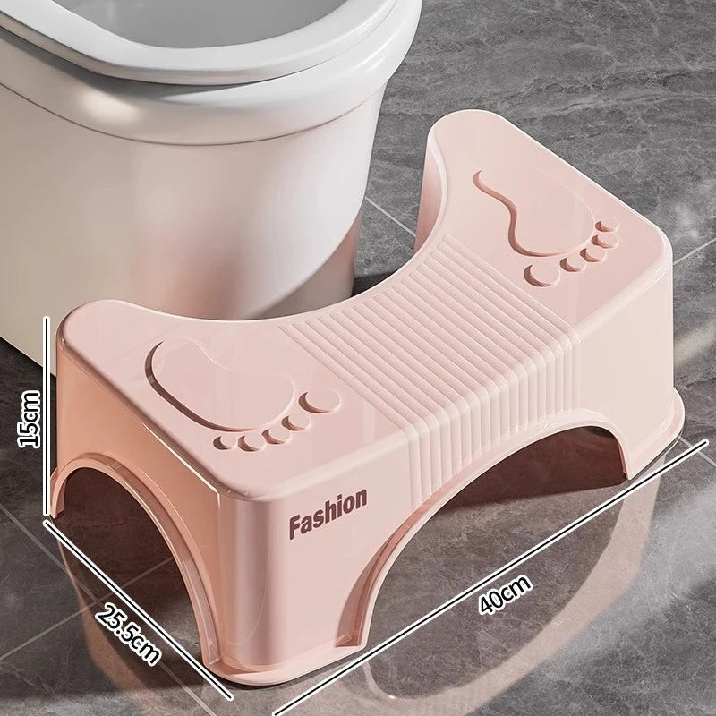Pink toilet stool next to a toilet with dimensions indicated