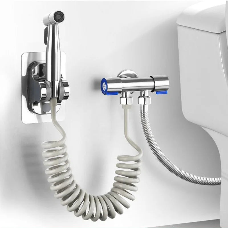 Wall-mounted shower head with coiled hose attached to a white wall.