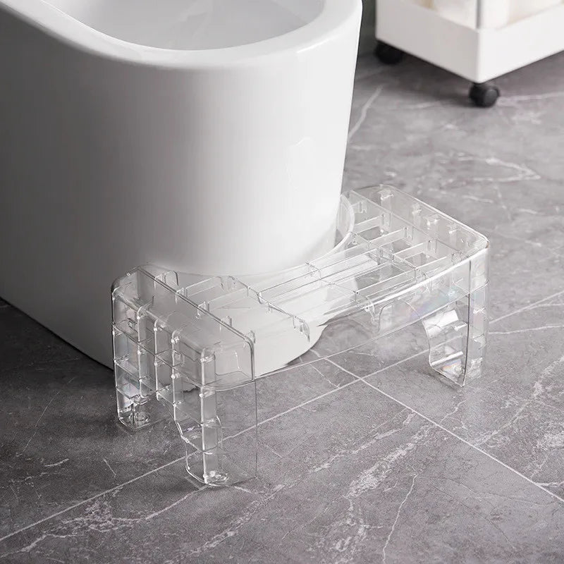 Clear plastic step stool next to a white toilet
